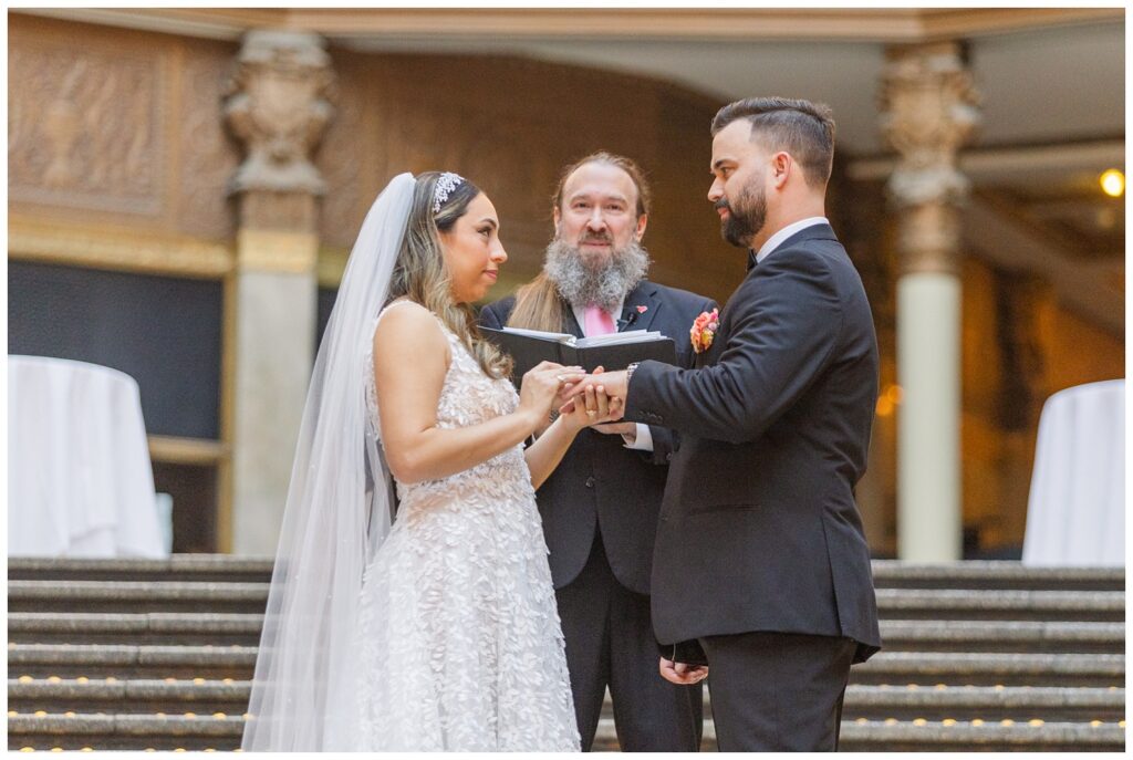 wedding couple exchanging rings on the stairs at Arcade Cleveland ceremony