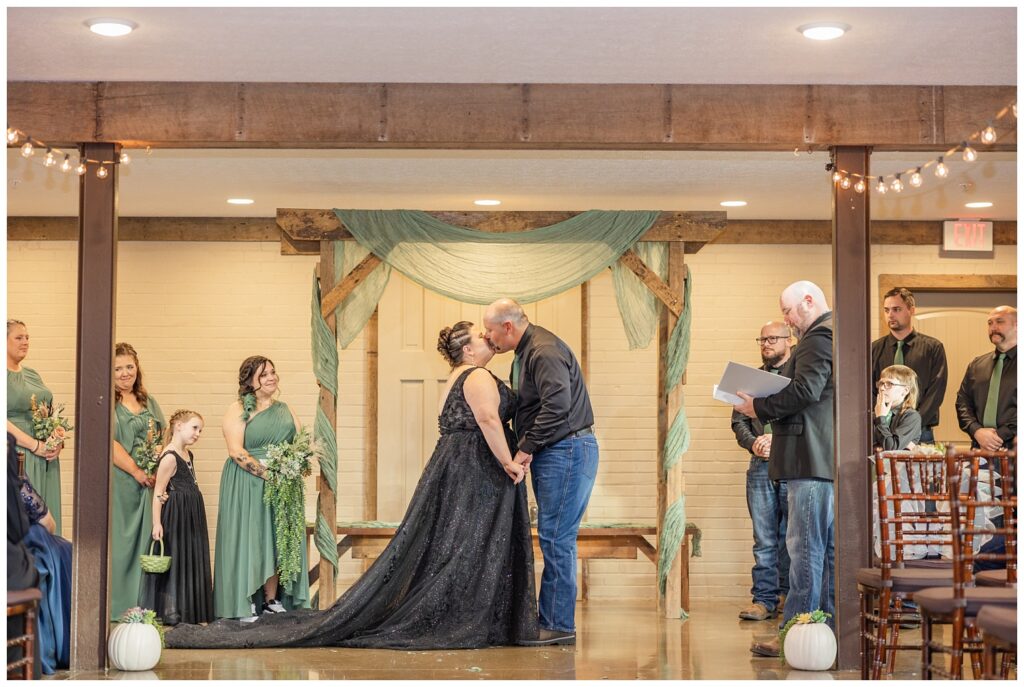 wedding couple share a kiss at the end of the ceremony inside the chapel at Pickwick Place