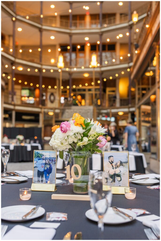 table centerpieces for reception with vases of flowers and framed portraits of the couple