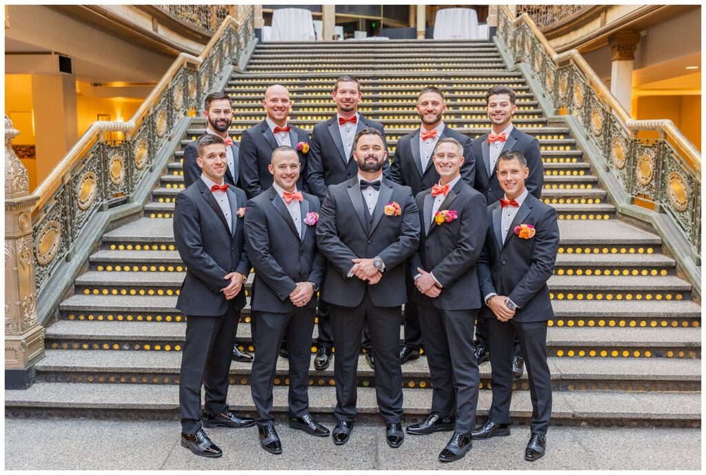 groomsmen party posing at the bottom of the stairs before ceremony