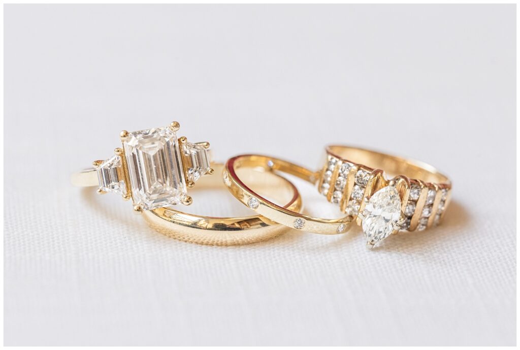 bride's wedding and family rings posed stacked on a white flat lay mat