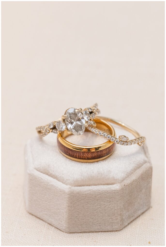 bride and groom's wedding rings sitting on top of a beige ring box 