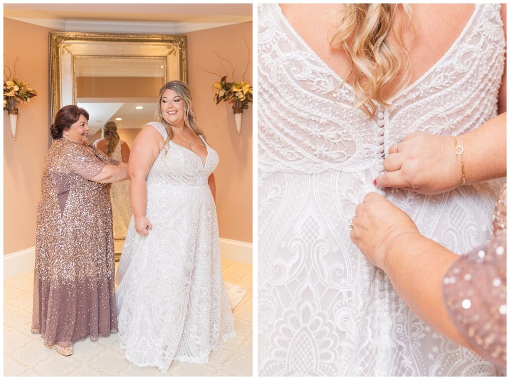 bride's mom zipping up the bride's dress in front of a large mirror 