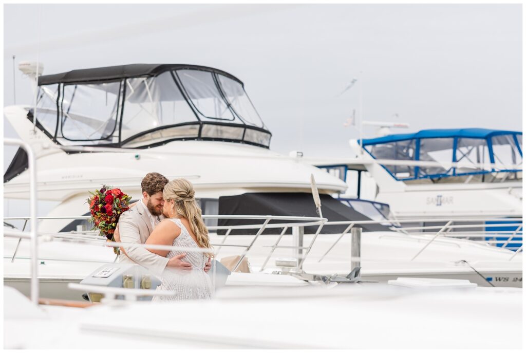 wedding couple hugging in between the boats at the Sandusky Yacht Club