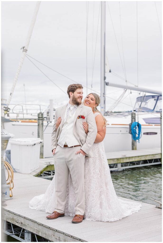 bride hugging the groom from behind on the gangway at the Sandusky Yacht Club