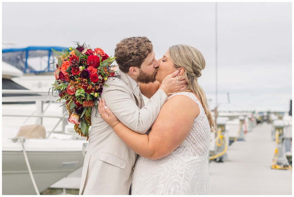 wedding couple share a kiss on the gangway among the boats at the Sandusky Yacht Club