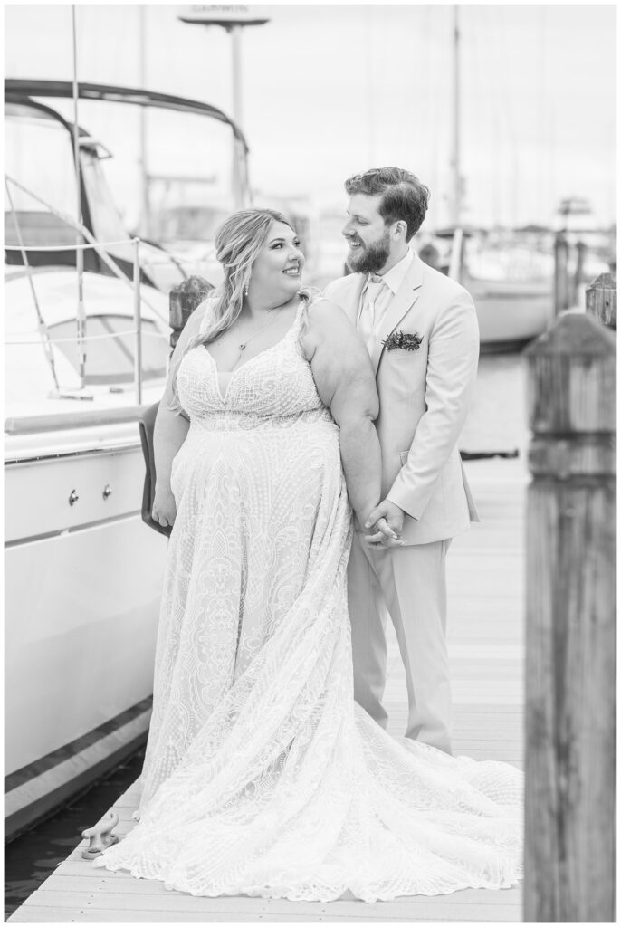 wedding couple posing together next to boats at yacht club in Sandusky