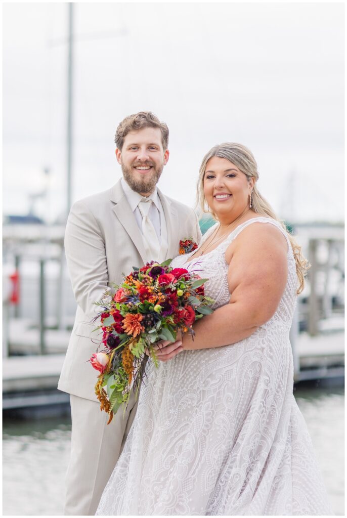 bride and groom both holding the bridal bouquet at the Sandusky Yacht Club