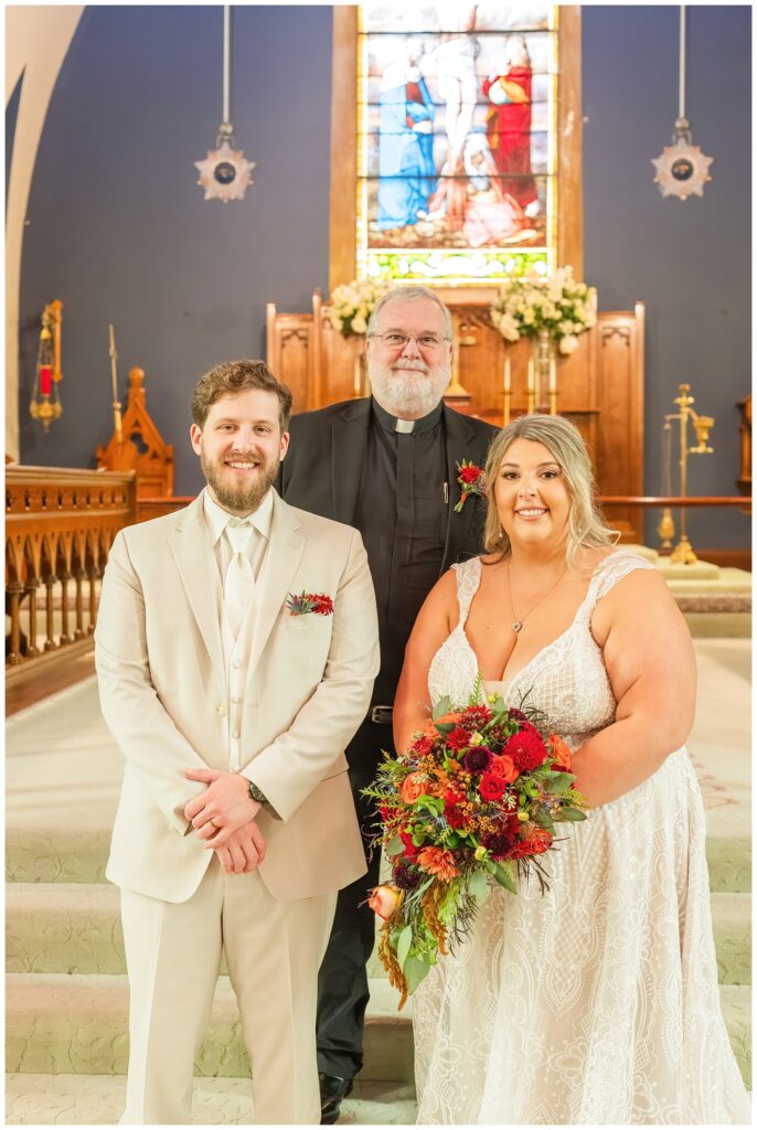 wedding couple posing with the pastor after fall wedding in Sandusky