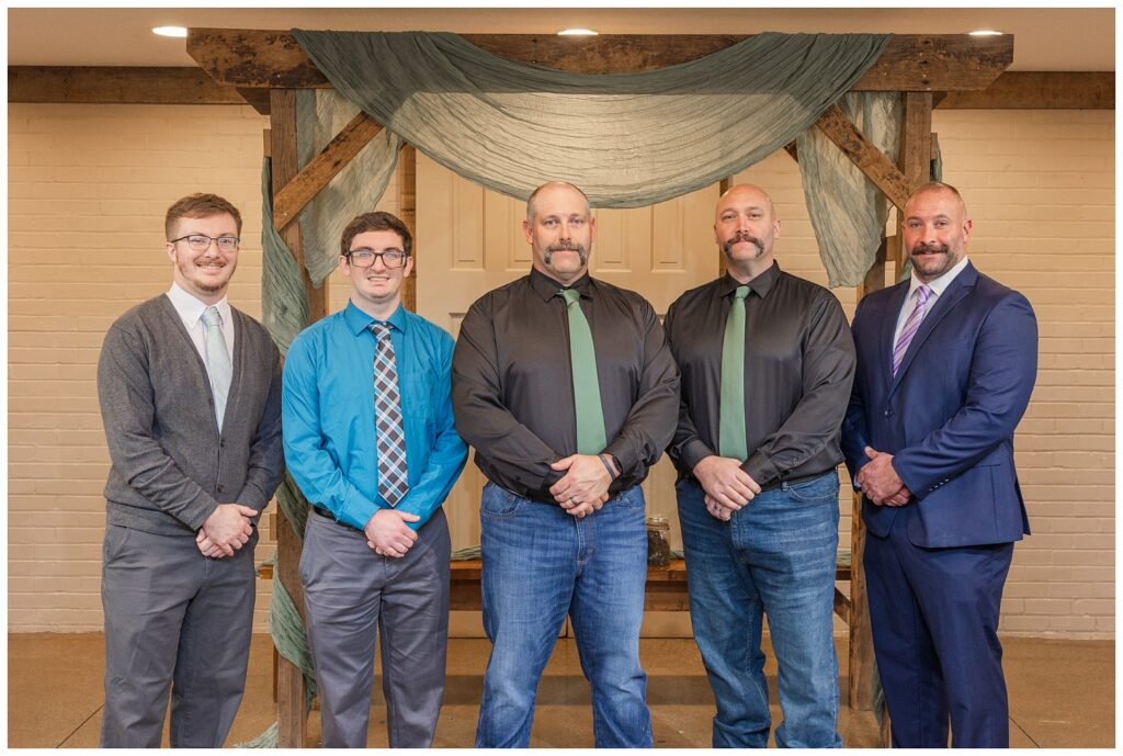 groom posing with his brother and family members at the chapel for portraits 