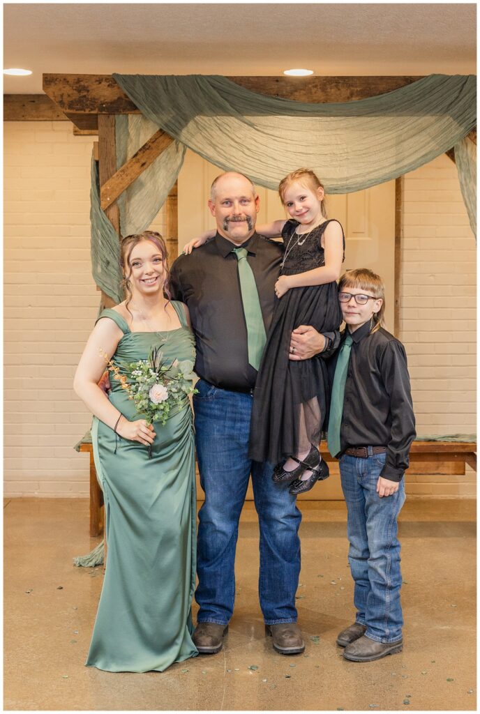 groom posing with his three children at fall wedding in Bucyrus, Ohio