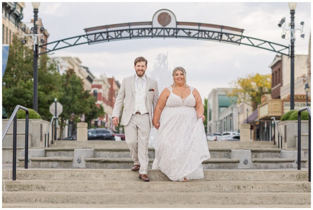 wedding couple walking down the stairs near the fountain in downtown Sandusky