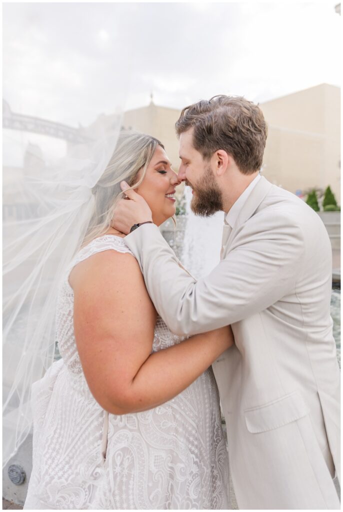 wedding couple touching noses under the bride's veil in downtown Sandusky