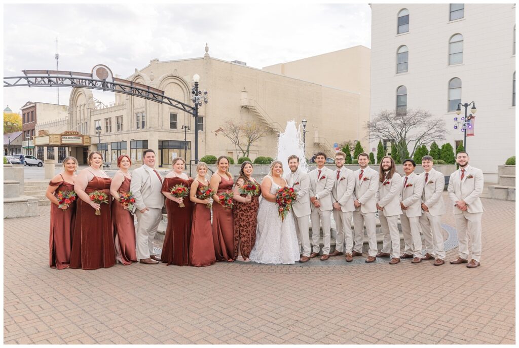 full wedding party posing in front of the fountain in downtown Sandusky this fall