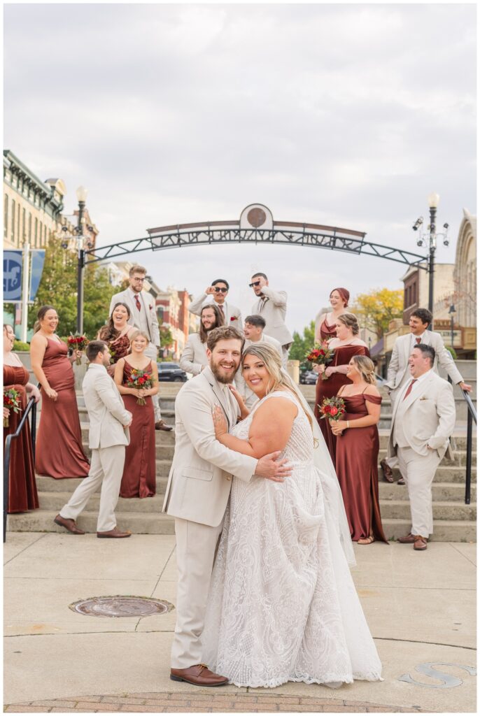 bride and groom hugging in front of the wedding party in downtown Sandusky