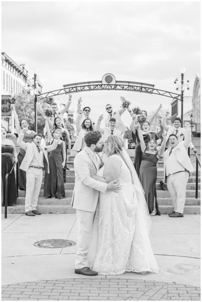 bride and groom kissing in front of the cheering wedding party in downtown Sandusky