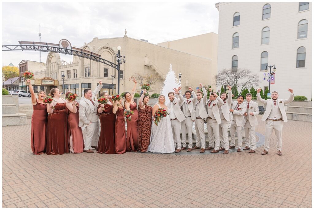 bride and groom posing together with party in front of the fountain in Sandusky, Ohio