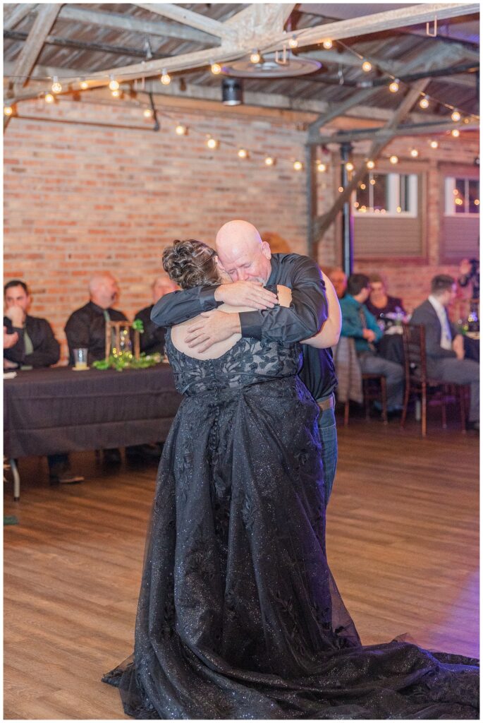 bride's dad giving the bride a big hug while the share a dance during wedding reception