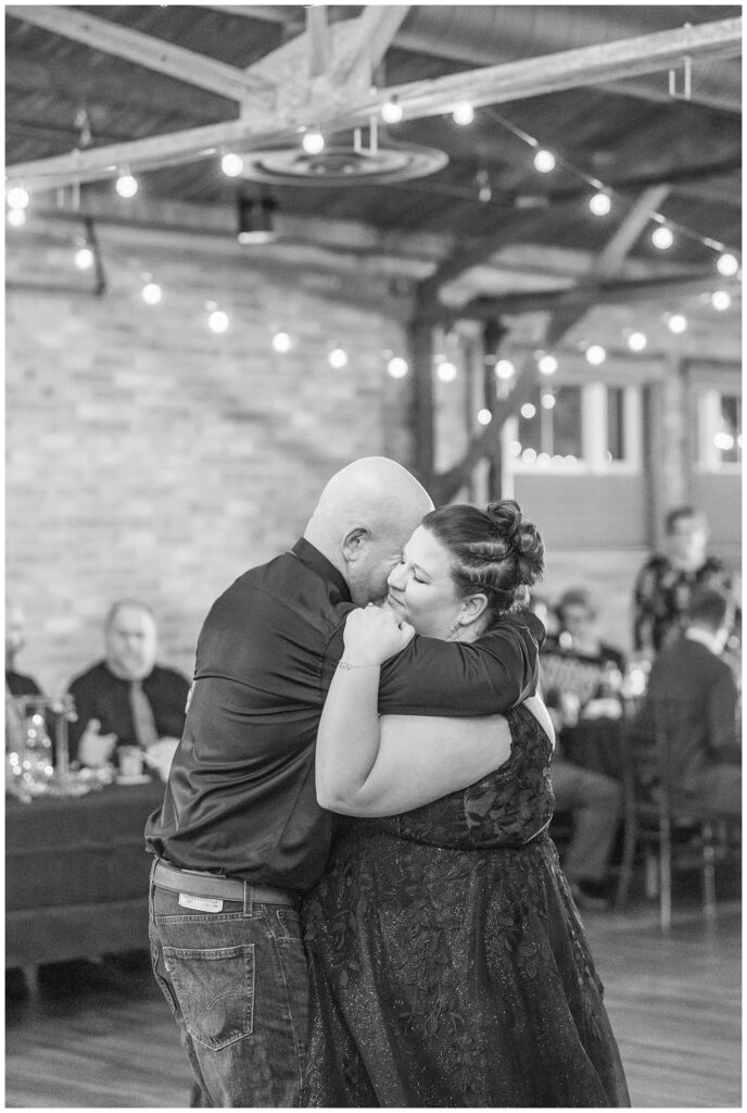 bride's dad giving the bride a big hug while the share a dance during wedding reception