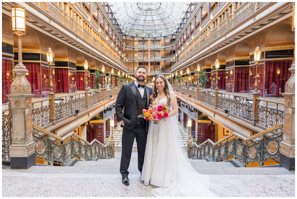 wedding couple posing together at the top of the stairs at the Arcade