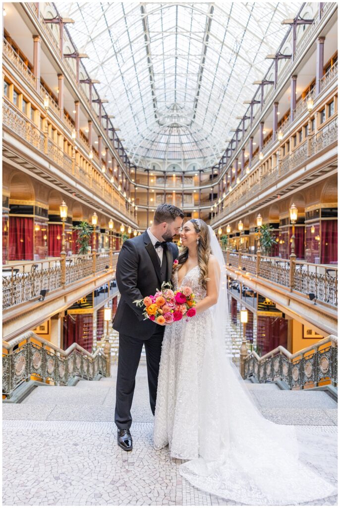 bride and groom posing on the stairs of the Arcade Cleveland before ceremony