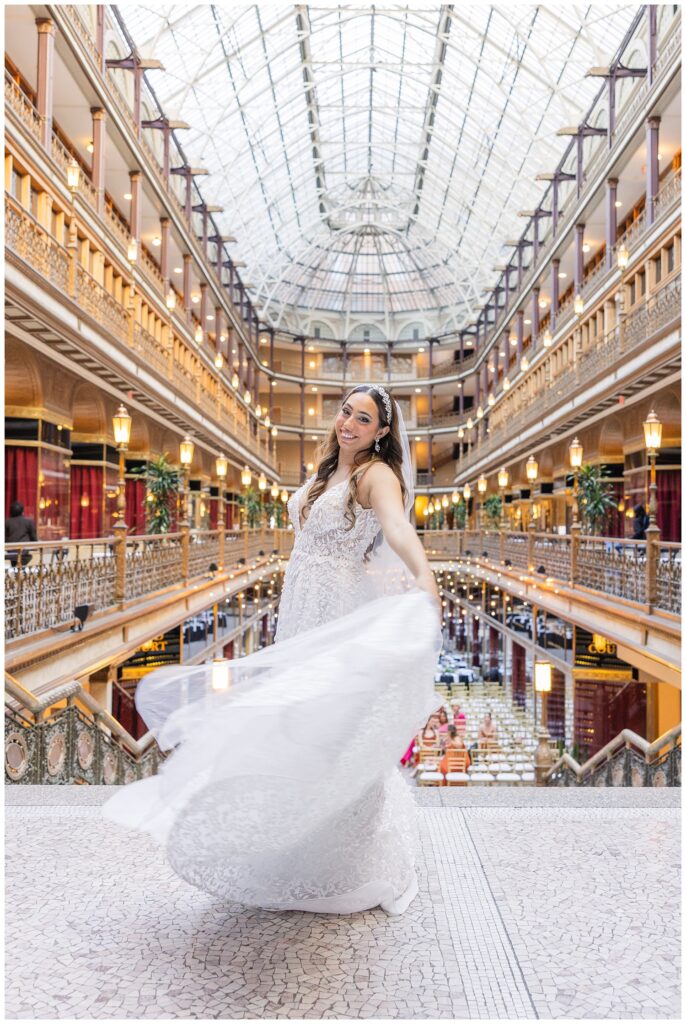 bride twirling her train at the top of the stairs at the Arcade