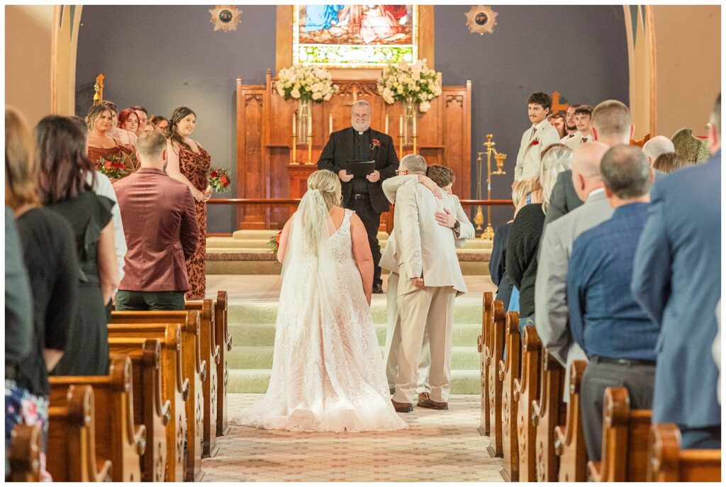 groom hugging the bride's dad during the ceremony at Old Calvary Church