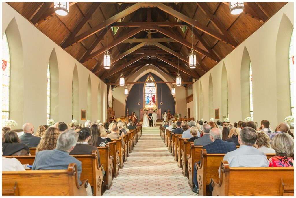 bride and groom holding hands during fall wedding ceremony in Sandusky church