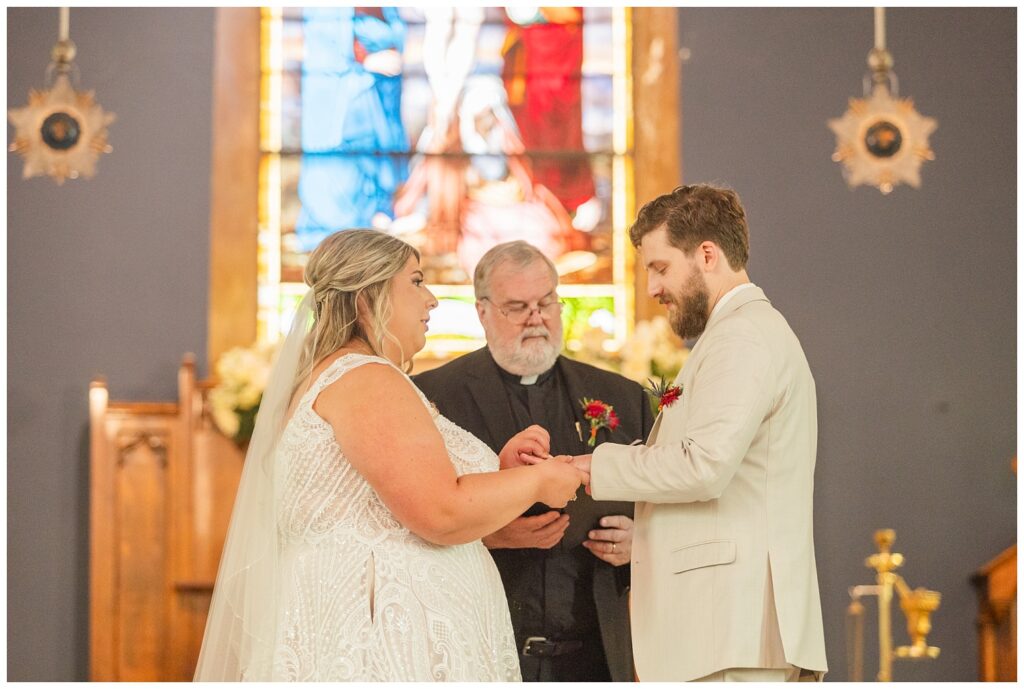 bride placing the ring on the groom's finger during fall wedding in Sandusky