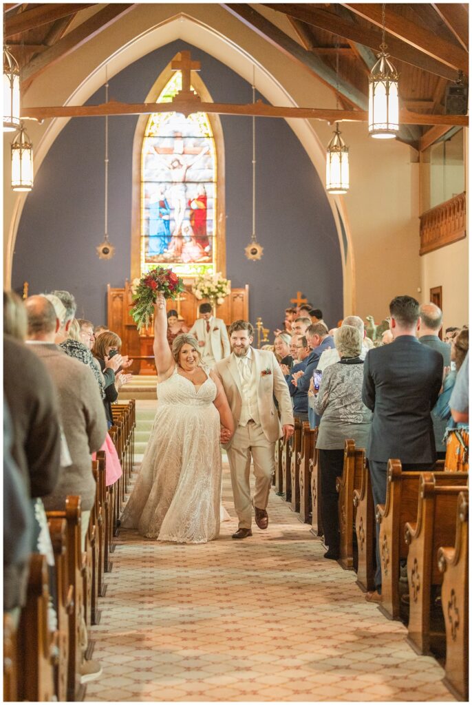 groom and bride walking back down the aisle at the end of the ceremony at the Old Calvary Church in Sandusky