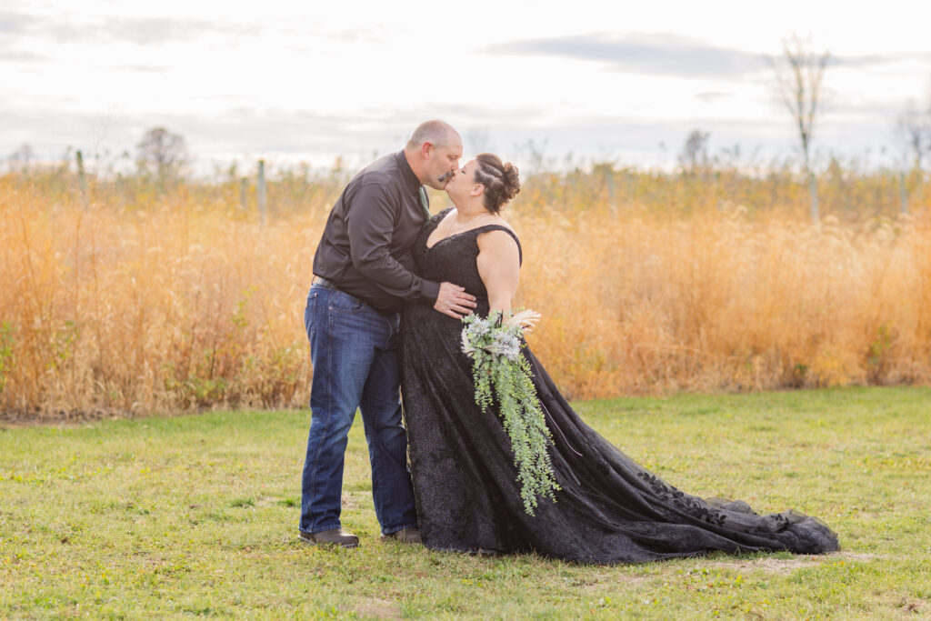 wedding couple sharing a kiss in front of a tall field at Pickwick Place