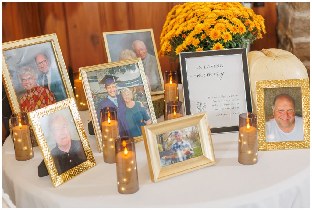 memory table of framed photos of loved ones of the bride and groom at reception