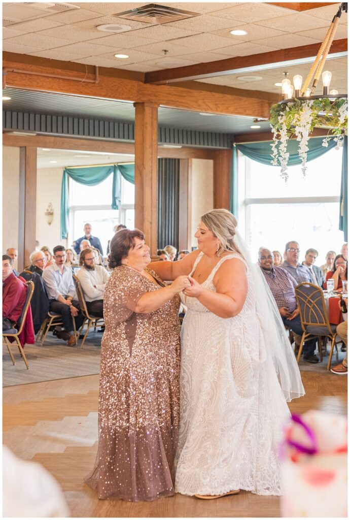 bride and her mom having a dance together at their fall wedding reception