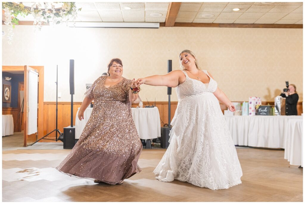 bride and her mom having a dance together at their fall wedding reception