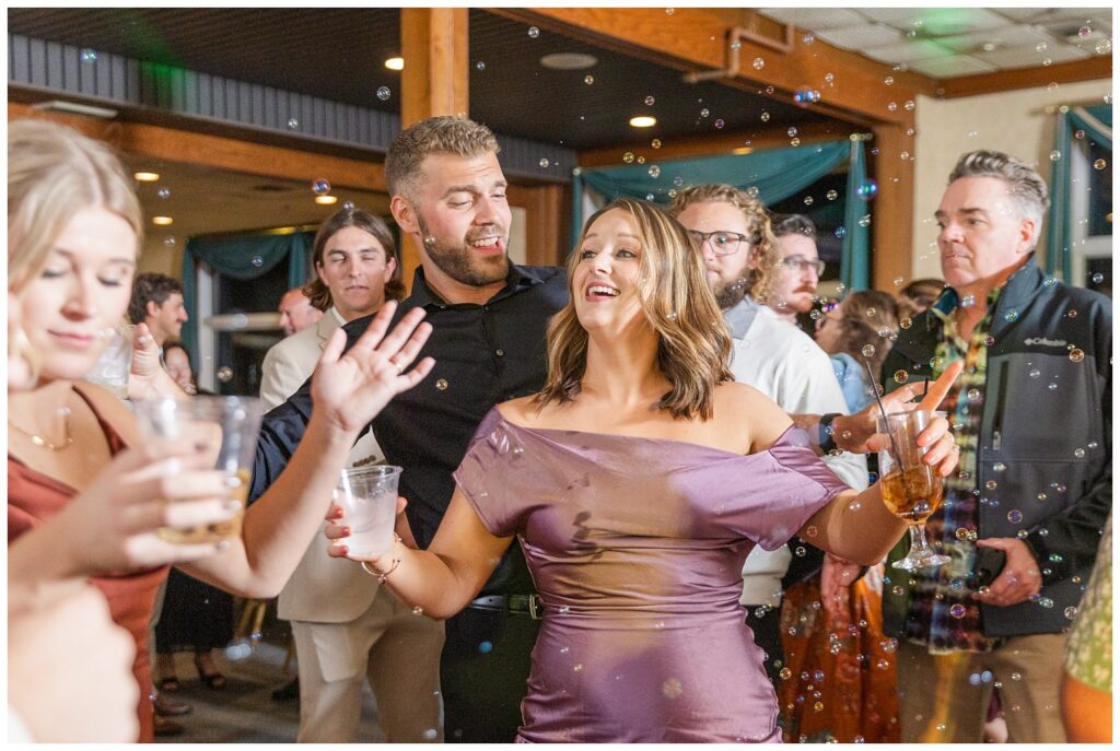 wedding guests dancing around bubbles at fall reception at the Sandusky Yacht Club