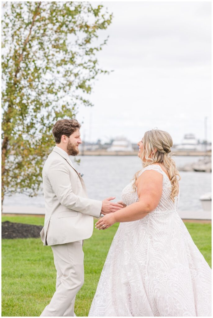 bride and groom having first look near the water at Sandusky Yacht Club