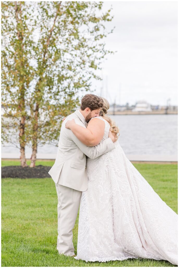 bride and groom hugging at first look near the water at Sandusky Yacht Club