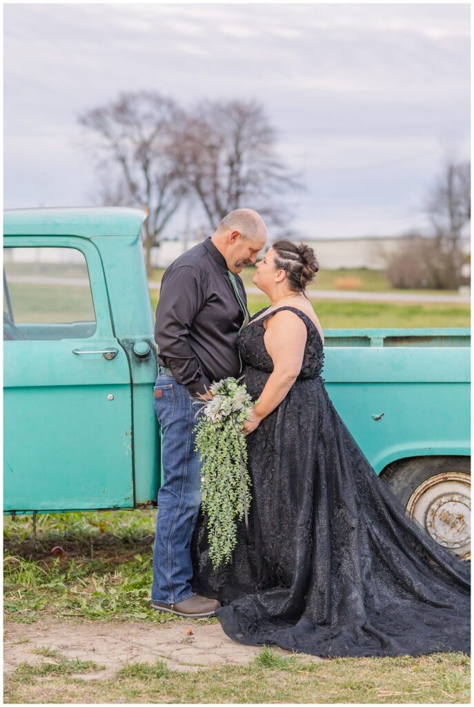 wedding couple posing next to an old teal green truck on the property at Pickwick Place in Bucyrus, Ohio