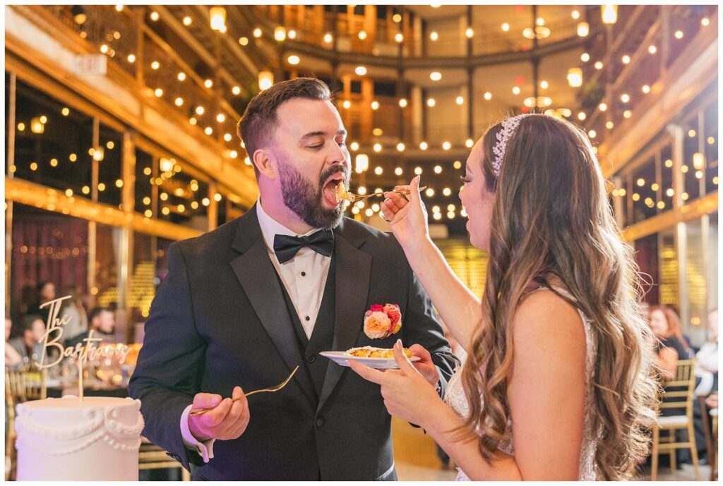 bride feeding the groom cake at fall wedding reception in Cleveland