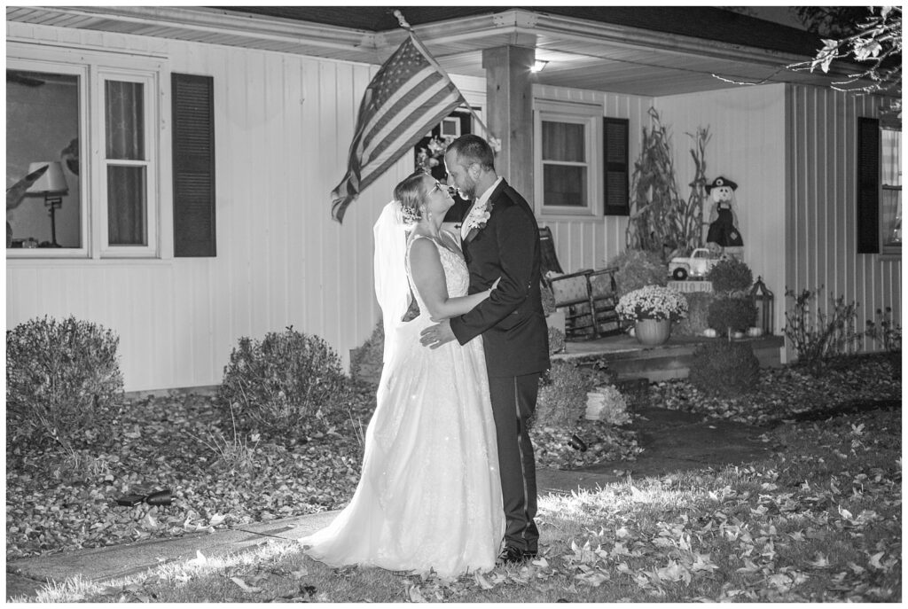 bride and groom hold each other in front of their house before the reception