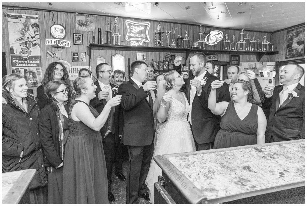 entire wedding party visiting the local bar for a shot before the reception at the Village Barn