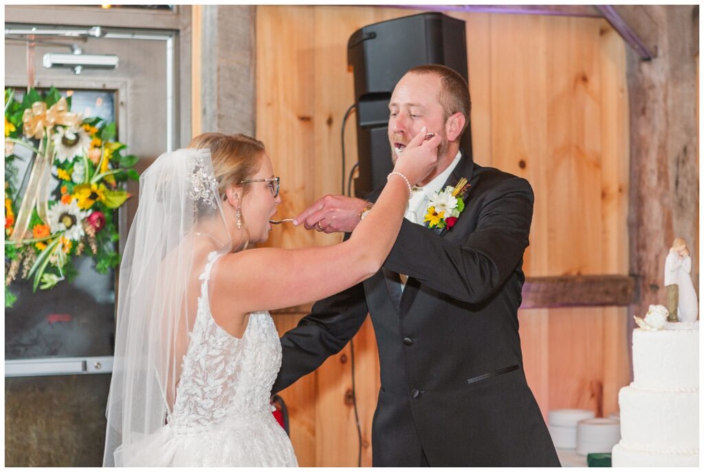 wedding couple cutting their cake at fall reception at the Village Barn