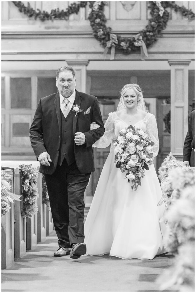 bride and her dad walking down the aisle at winter church ceremony