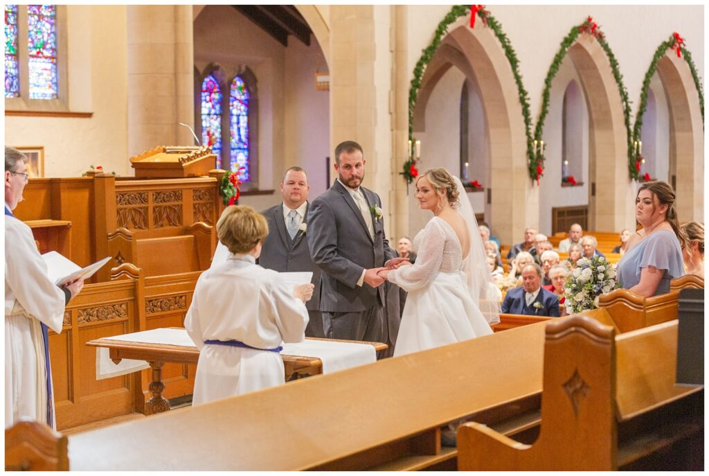 bride and groom holding hands and saying their vows during church wedding