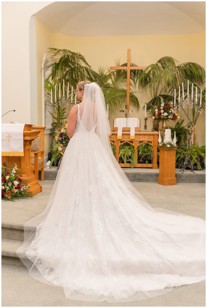 bride posing in the church showing off the back of her dress in Monroeville, OH