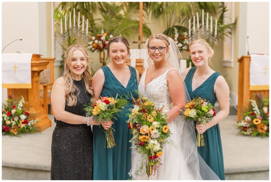 bride posing with her family in front of the altar before the ceremony 