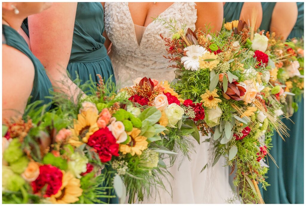 close up detail of the bride and bridesmaids' bouquets of roses, carnations, and daises