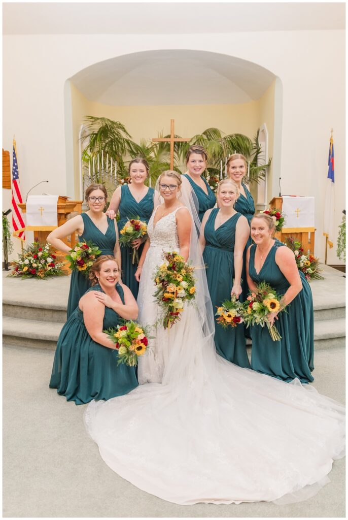 bridesmaids and bride posing together in front of the church altar in Ohio