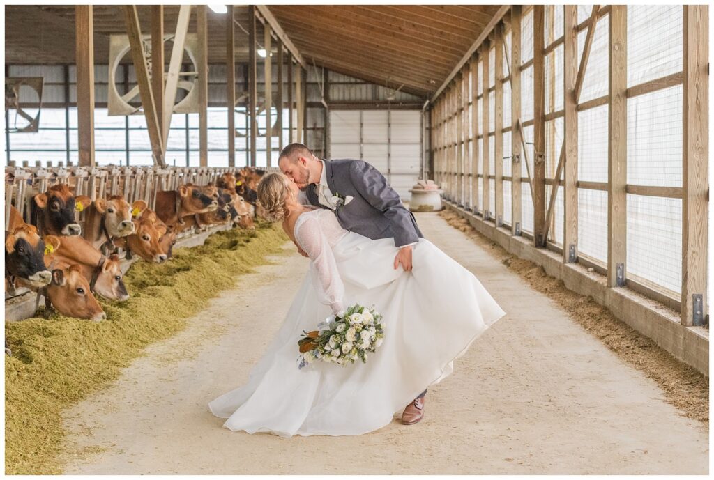 groom dipping the bride back for a kiss while she is holding her bouquet