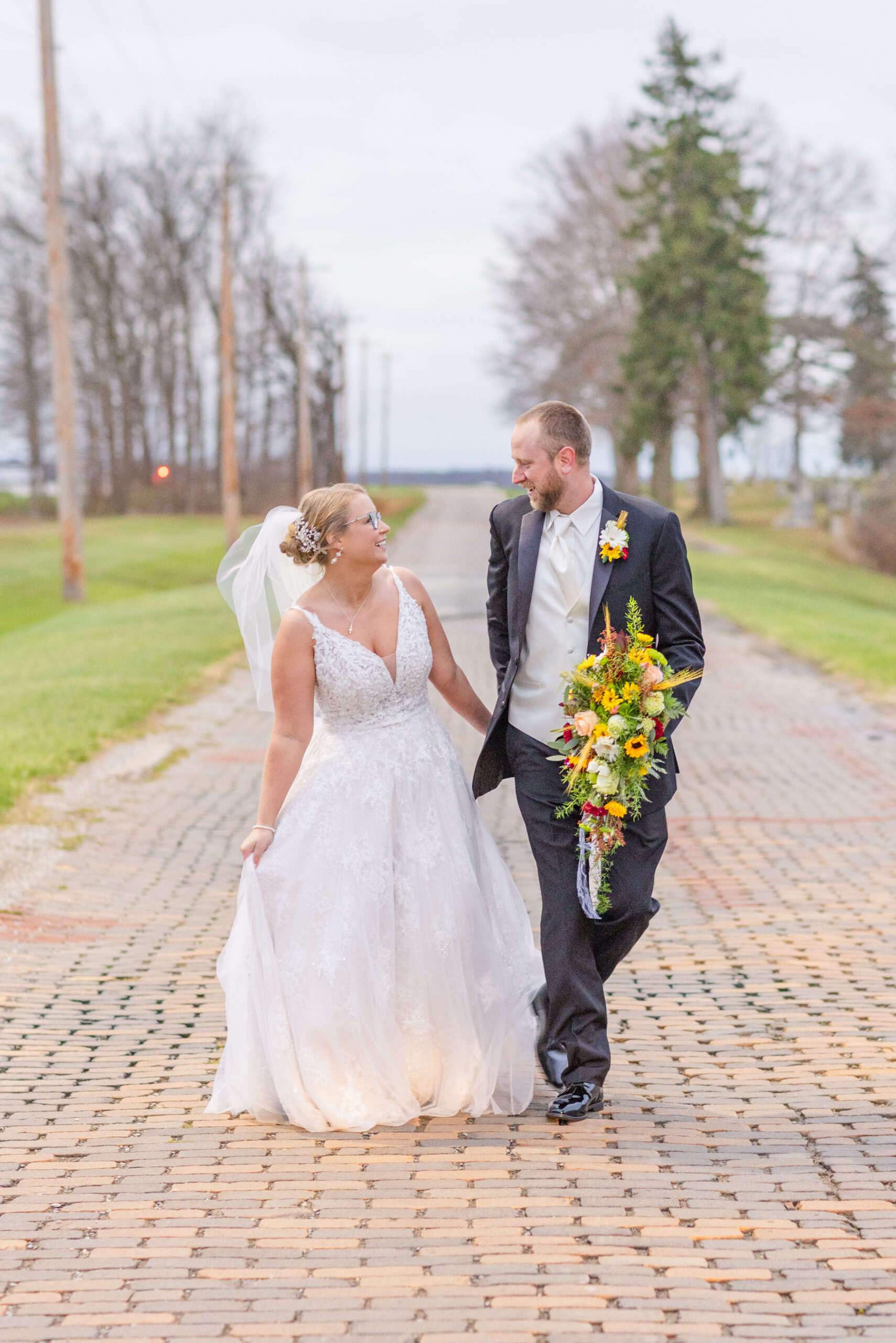 bride and groom walking along a brick road in Ohio